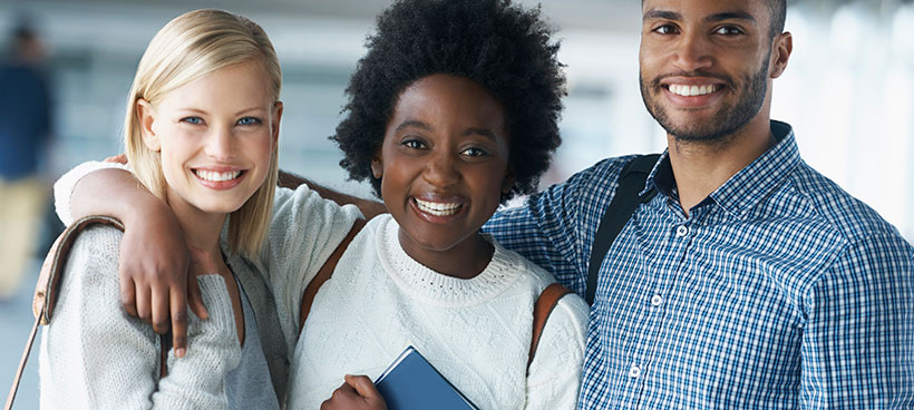 three students with arms around each other