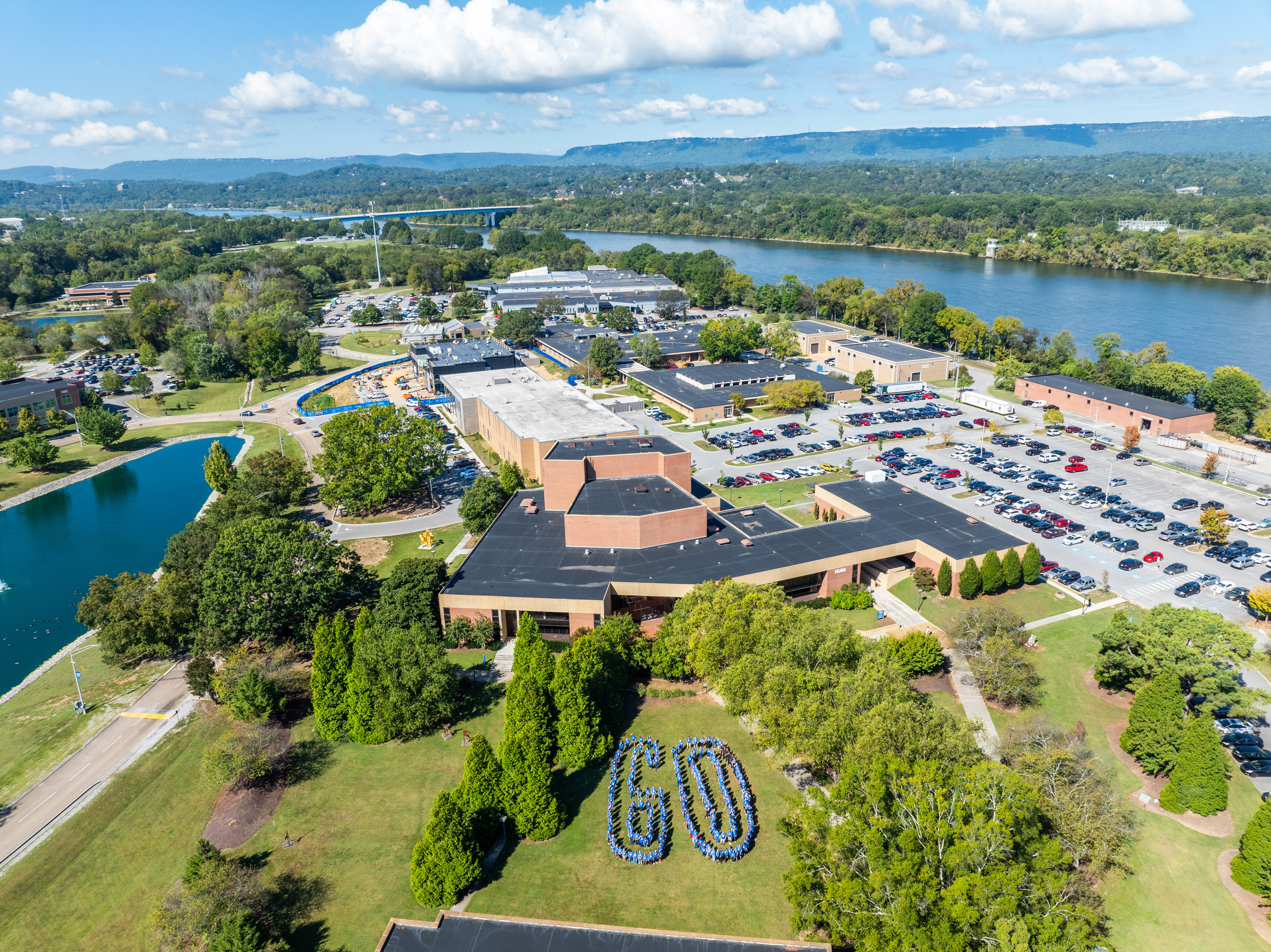 Aerial view of Chattanooga State Community College campus with buildings, parking lots, green spaces, and the river in the background.
